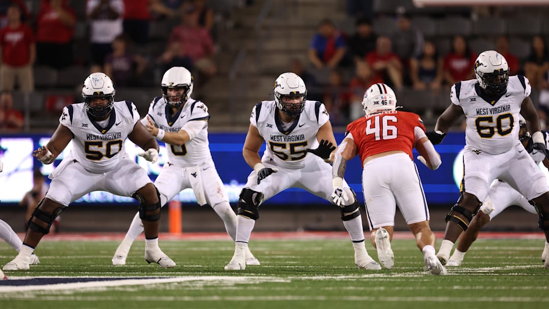 The WVU football offensive line protects Mountaineers' quarterback Nicco Marchiol against Arizona during the 2024 season.
