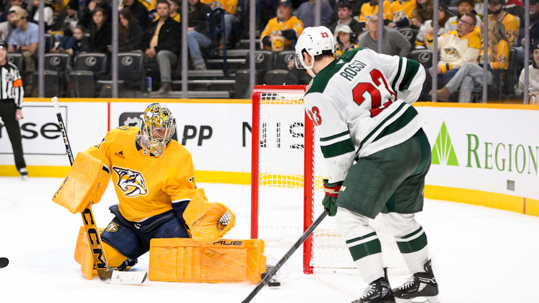 Jan 18, 2025; Nashville, Tennessee, USA;  Nashville Predators goaltender Juuse Saros (74) blocks the shot of Minnesota Wild center Marco Rossi (23) during the second period at Bridgestone Arena. Mandatory Credit: Steve Roberts-Imagn Images