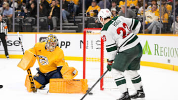Jan 18, 2025; Nashville, Tennessee, USA;  Nashville Predators goaltender Juuse Saros (74) blocks the shot of Minnesota Wild center Marco Rossi (23) during the second period at Bridgestone Arena. Mandatory Credit: Steve Roberts-Imagn Images