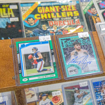 Rare sports cards, some graded for quality, sit in a display shelf at the new shop Stooges Comics & Collectibles in the Oak Cliff Park shopping center in Peoria.