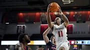 Nov 10, 2023; Cincinnati, Ohio, USA;  Cincinnati Bearcats guard CJ Anthony (11) drives to the basket against Detroit Mercy Titans guard Jayden Stone (14) and guard Abdullah Olajuwon (7) in the second half at Fifth Third Arena. Mandatory Credit: Aaron Doster-Imagn Images