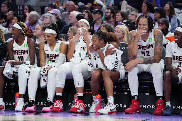 Atlanta Dream players, including center Brittney Griner, laugh on the bench. 