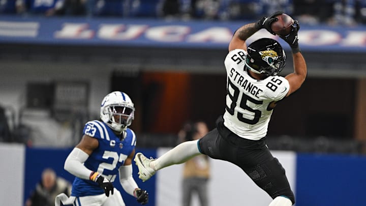 Jan 5, 2025; Indianapolis, Indiana, USA; Jacksonville Jaguars tight end Brenton Strange (85) jumps to catch a ball in front of Indianapolis Colts cornerback Kenny Moore II (23) during the second half at Lucas Oil Stadium. Mandatory Credit: Marc Lebryk-Imagn Images