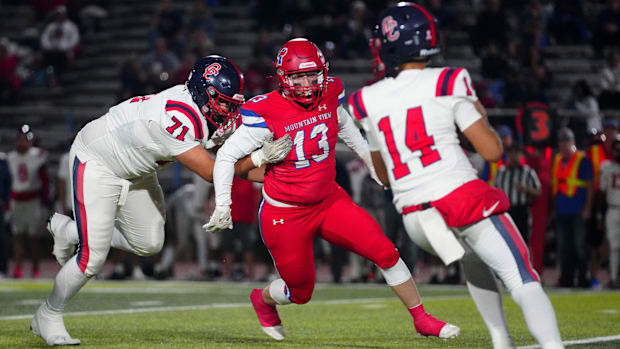 Mountain View defensive end Parker Foster (13) rushes Centennial quarterback Titus Hill (14) during a playoff game at Mountai