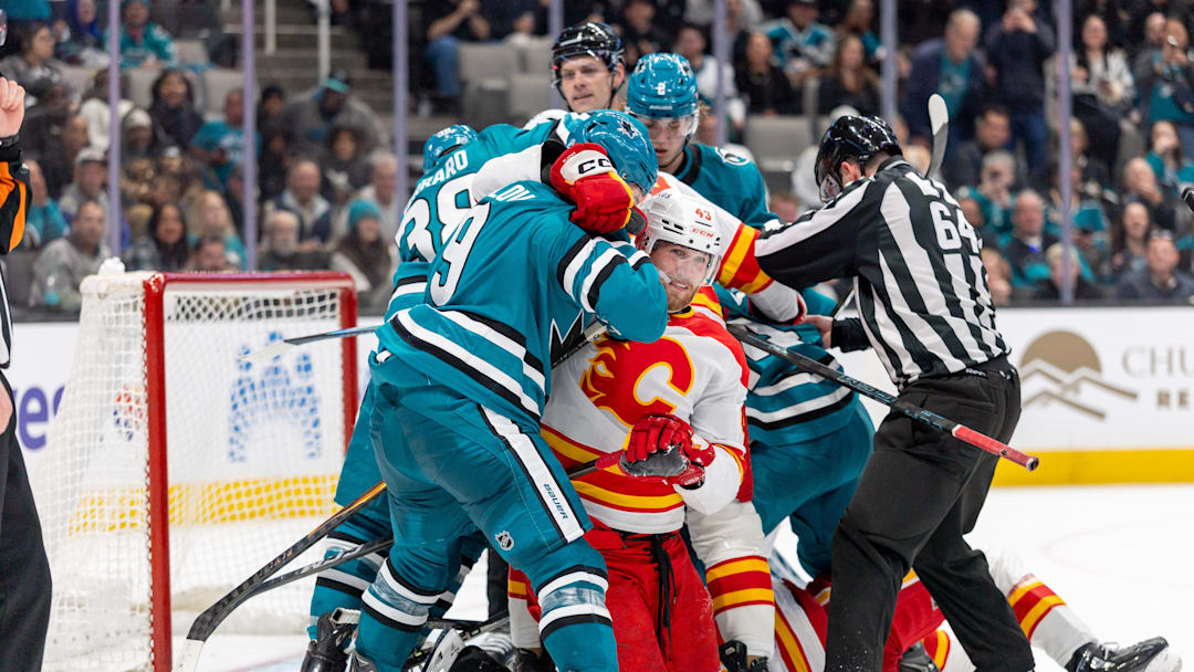 Feb 26, 2026; San Jose, California, USA; Referees break up a fight between the San Jose Sharks and Calgary Flames during the third period at SAP Center at San Jose. Mandatory Credit: Bob Kupbens-Imagn Images