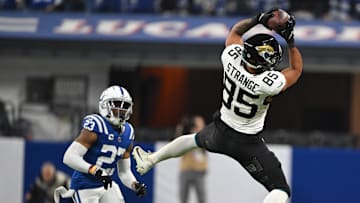 Jan 5, 2025; Indianapolis, Indiana, USA; Jacksonville Jaguars tight end Brenton Strange (85) jumps to catch a ball in front of Indianapolis Colts cornerback Kenny Moore II (23) during the second half at Lucas Oil Stadium. Mandatory Credit: Marc Lebryk-Imagn Images