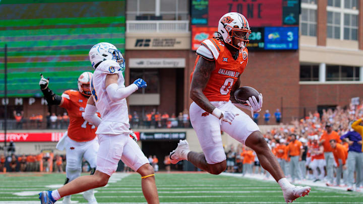 Aug 31, 2024; Stillwater, Oklahoma, USA; Oklahoma State Cowboys running back Ollie Gordon II (0) leaps into the endzone for a touchdown during the second quarter against the South Dakota State Jackrabbits at Boone Pickens Stadium. Mandatory Credit: William Purnell-Imagn Images