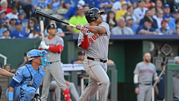 Kansas City, Missouri, USA; Boston Red Sox designated hitter Rafael Devers (11) hits an RBI double in the third inning against the Kansas City Royals at Kauffman Stadium.