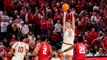Dec 10, 2025; Lincoln, Nebraska, USA; Nebraska Cornhuskers forward Pryce Sandfort (21) shoots a three point basket against Wisconsin Badgers guard Nick Boyd (2) and guard John Blackwell (25) during the first half at Pinnacle Bank Arena. 