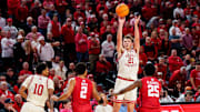 Dec 10, 2025; Lincoln, Nebraska, USA; Nebraska Cornhuskers forward Pryce Sandfort (21) shoots a three point basket against Wisconsin Badgers guard Nick Boyd (2) and guard John Blackwell (25) during the first half at Pinnacle Bank Arena. 