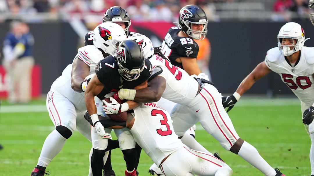 Dec 21, 2025; Glendale, Arizona, USA;  Atlanta Falcons running back Bijan Robinson (7) carries the ball as Arizona Cardinals safety Budda Baker (3) attempts to make the tackle during the first half at State Farm Stadium. Mandatory Credit: Joe Camporeale-Imagn Images