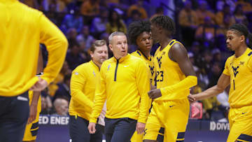 Nov 13, 2025; Morgantown, West Virginia, USA; West Virginia Mountaineers head coach Ross Hodge talks with West Virginia Mountaineers guard Morris Ugusuk (23) during the first half against the Pittsburgh Panthers at WVU Coliseum. Mandatory Credit: Ben Queen-Imagn Images