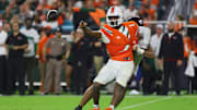 Sep 27, 2024; Miami Gardens, Florida, USA; Miami Hurricanes quarterback Cam Ward (1) throws the football as Virginia Tech Hokies defensive lineman Wilfried Pene (91) attempts a tackle during the second quarter at Hard Rock Stadium. Mandatory Credit: Sam Navarro-Imagn Images