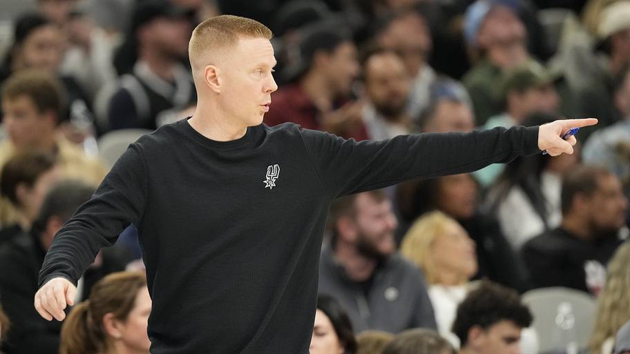 San Antonio Spurs assistant head coach Sean Sweeney signals to players.