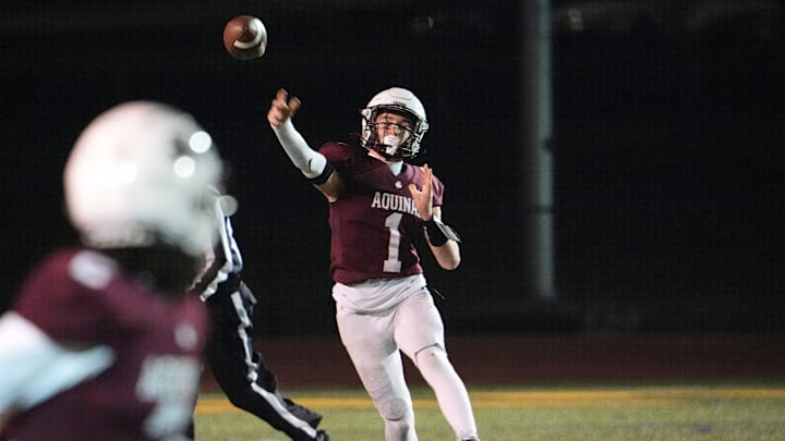 Aquinas quarterback Trent Buttles looks downfield for Alexis Rosado. Aquinas quarterback Trent Buttles looks downfield for Alexis Rosado.