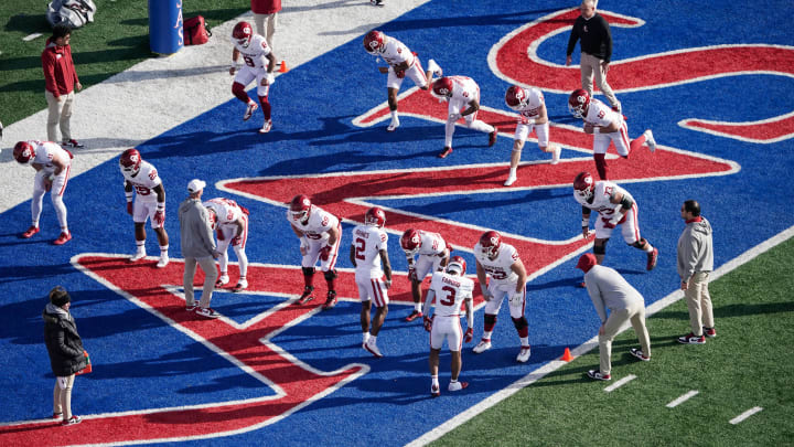 Oct 28, 2023; Lawrence, Kansas, USA;  Members of the Oklahoma Sooners team stretch on field prior to