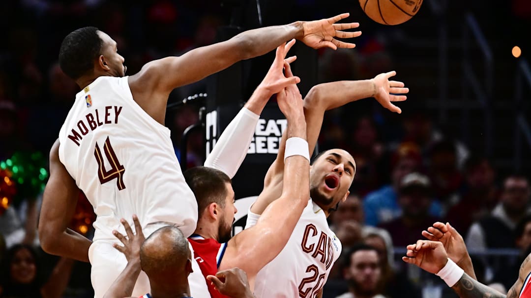 Nov 23, 2025; Cleveland, Ohio, USA; Los Angeles Clippers center Ivica Zubac (40) goes for a rebound against Cleveland Cavaliers center Evan Mobley (4) and guard Jaylon Tyson (20) during the second half at Rocket Arena. Mandatory Credit: Ken Blaze-Imagn Images
