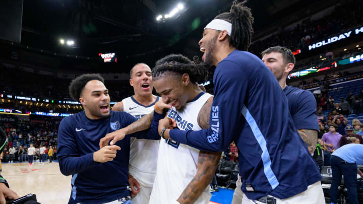 Dec 19, 2023; New Orleans, Louisiana, USA; Memphis Grizzlies guard Ja Morant, center, is mobbed by teammates Jacob Gilyard, left, and Ziaire Williams, after scoring the winning basket to defeat the New Orleans Pelicans at the Smoothie King Center. 