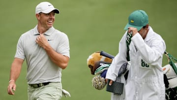 Rory McIlroy laughs with his caddie during The Masters