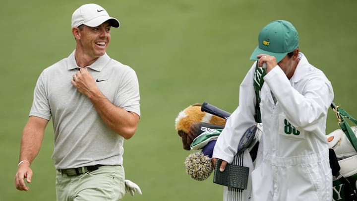 Rory McIlroy laughs with his caddie during The Masters