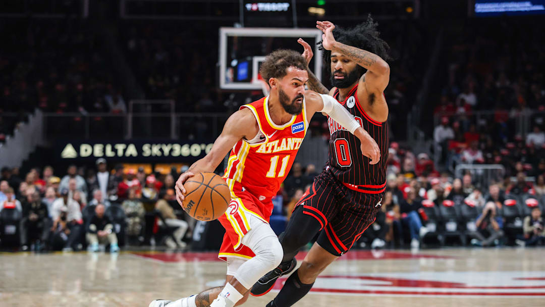 Dec 23, 2025; Atlanta, Georgia, USA; Atlanta Hawks guard Trae Young (11) dribbles the ball toward the basket against Chicago Bulls guard Coby White (0) during the first quarter at State Farm Arena. Mandatory Credit: Jordan Godfree-Imagn Images