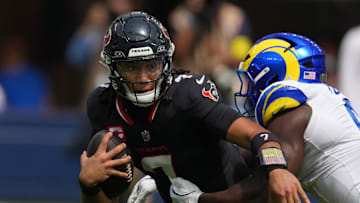Sep 7, 2025; Inglewood, California, USA; Houston Texans quarterback C.J. Stroud (7) is pressured by Los Angeles Rams linebacker Byron Young (0) in the first half at SoFi Stadium. Mandatory Credit: Kirby Lee-Imagn Images