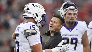 Sep 5, 2025; Louisville, Kentucky, USA;  James Madison Dukes head coach Bob Chesney talks with tight end Lacota Dippre (15) during the first quarter against the Louisville Cardinals at L&N Federal Credit Union Stadium. Mandatory Credit: Jamie Rhodes-Imagn Images