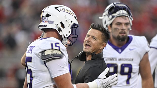James Madison Dukes head coach Bob Chesney talks with tight end Lacota Dippre during a game against the Louisville Cardinals.