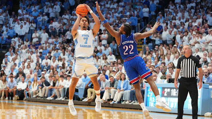 Nov 7, 2025; Chapel Hill, North Carolina, USA;  North Carolina Tar Heels guard Seth Trimble (7) shoots as Kansas Jayhawks guard Darryn Peterson (22) defends in the second half at Dean E. Smith Center. Mandatory Credit: Bob Donnan-Imagn Images