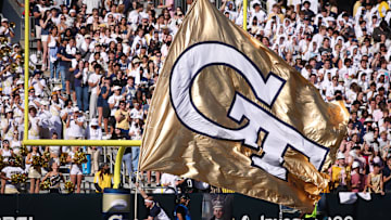 Oct 11, 2025; Atlanta, Georgia, USA; Georgia Tech Yellow Jackets cheerleader runs a flag after a touchdown against the Virginia Tech Hokies in the first quarter at Bobby Dodd Stadium at Hyundai Field. Mandatory Credit: Brett Davis-Imagn Images
