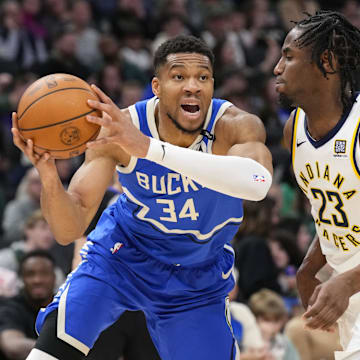 Mar 15, 2025; Milwaukee, Wisconsin, USA;  Milwaukee Bucks forward Giannis Antetokounmpo (34) looks to pass the ball around Indiana Pacers forward Aaron Nesmith (23) during the third quarter at Fiserv Forum. Mandatory Credit: Jeff Hanisch-Imagn Images