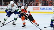 Oct 19, 2024; Philadelphia, Pennsylvania, USA; Philadelphia Flyers right wing Matvei Michkov (39) reaches for the puck against Vancouver Canucks defenseman Vincent Desharnais (73) in the second period at Wells Fargo Center. Mandatory Credit: Kyle Ross-Imagn Images