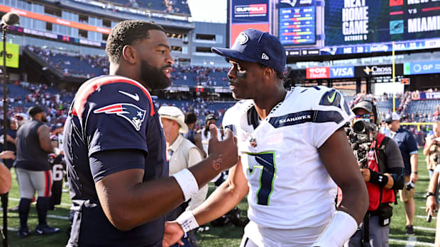 New England Patriots quarterback Jacoby Brissett (7) talks with Seattle Seahawks quarterback Geno Smith 