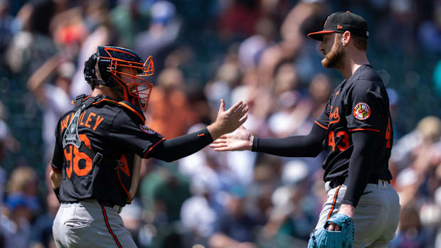 Baltimore Orioles pitcher Bryan Baker and catcher Maverick Handley celebrating in black uniforms. 