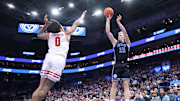 Nov 21, 2025; Salt Lake City, Utah, USA; BYU Cougars guard Richie Saunders (15) takes a three-point shot over Wisconsin Badgers guard Braeden Carrington (0) during the second half at Delta Center.