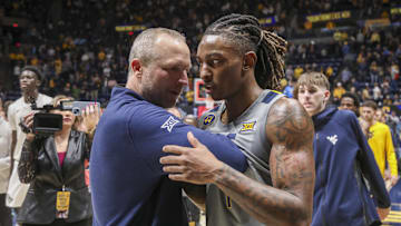 Mar 8, 2025; Morgantown, West Virginia, USA; West Virginia Mountaineers head coach Darian DeVries and guard Javon Small (7) celebrate after defeating the UCF Knights at WVU Coliseum. Mandatory Credit: Ben Queen-Imagn Images