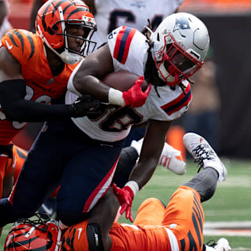 Cincinnati Bengals cornerback Mike Hilton (21) and Cincinnati Bengals cornerback Cam Taylor-Britt (29) tackled New England Patriots running back Rhamondre Stevenson (38) in the second quarter of the NFL game at Paycor Stadium in Cincinnati on Sunday, Sept. 8, 2024.