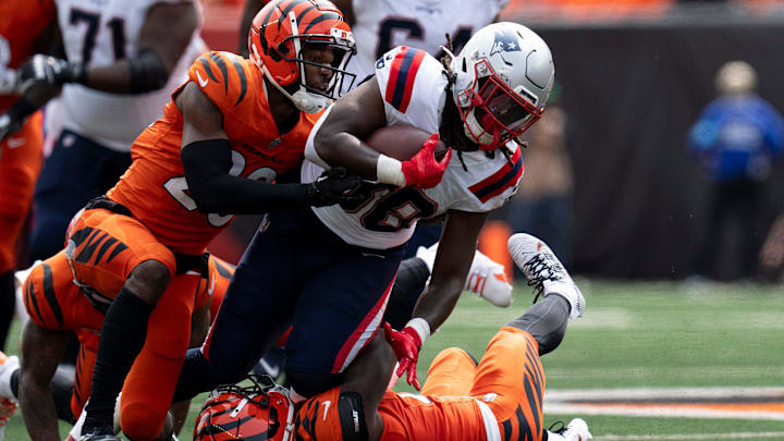 Cincinnati Bengals cornerback Mike Hilton (21) and Cincinnati Bengals cornerback Cam Taylor-Britt (29) tackled New England Patriots running back Rhamondre Stevenson (38) in the second quarter of the NFL game at Paycor Stadium in Cincinnati on Sunday, Sept. 8, 2024.