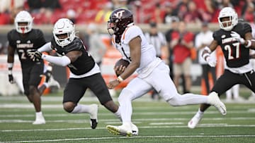 Nov 4, 2023; Louisville, Kentucky, USA;  Virginia Tech Hokies quarterback Kyron Drones (1) runs the ball against Louisville Cardinals linebacker Jaylin Alderman (24) during the second half at L&N Federal Credit Union Stadium. Louisville defeated Virginia Tech 34-3. Mandatory Credit: Jamie Rhodes-Imagn Images