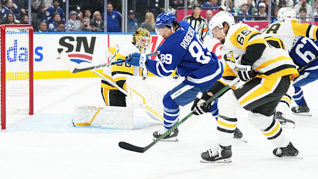 Hockey players battle for puc