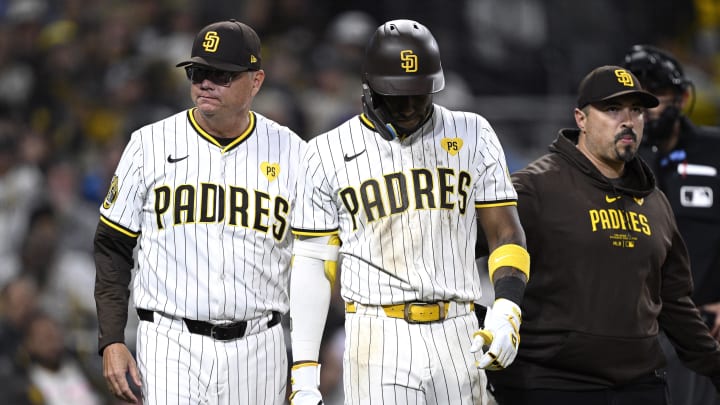 Jun 11, 2024; San Diego, California, USA; San Diego Padres left fielder Jurickson Profar (center) is helped off the field by manager Mike Shildt (left) after sustaining an injury during the eighth inning against the Oakland Athletics at Petco Park. Mandatory Credit: Orlando Ramirez-USA TODAY Sports