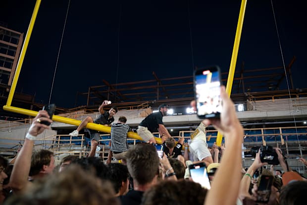 Exuberant fans on the goalpost in the end zone after Vanderbilt beat Alabama.