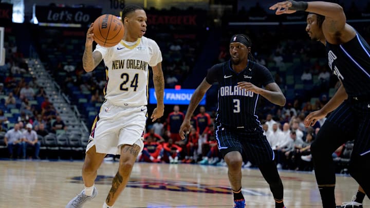 Oct 7, 2024; New Orleans, Louisiana, USA; New Orleans Pelicans guard Jordan Hawkins (24) dribbles next to Orlando Magic center Wendell Carter Jr. (34) and guard Kentavious Caldwell-Pope (3) during the second half at Smoothie King Center. Mandatory Credit: Matthew Hinton-Imagn Images