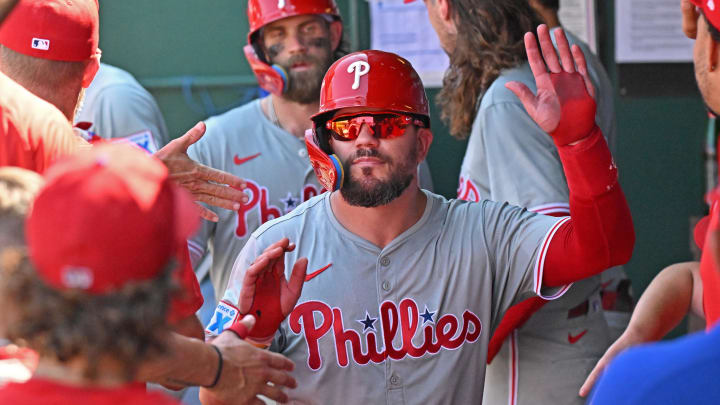 Aug 25, 2024; Kansas City, Missouri, USA;  Philadelphia Phillies designated hitter Kyle Schwarber (12) celebrates in the dugout after scoring a run in the eighth inning against the Kansas City Royals at Kauffman Stadium.