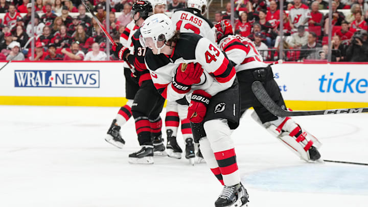 New Jersey Devils defenseman Luke Hughes clutches his shoulder after an injury during Game 1 vs. the Carolina Hurricanes.