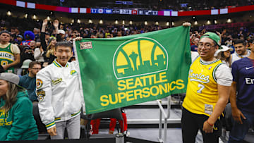 Fans hold a flag for the Seattle Supersonics during the fourth quarter of a game between the Utah Jazz and LA Clippers at Climate Pledge Arena. 
