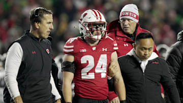 Wisconsin head coach Luke Fickell, left, helps safety Hunter Wohler (24) get off the field after being injured during the fourth quarter of their game Saturday, November 16, 2024 at Camp Randall Stadium in Madison, Wisconsin. Oregon beat Wisconsin 16-13.