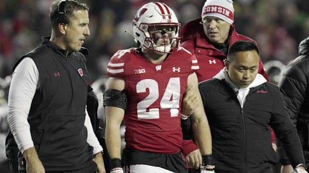 Colts defender Hunter Wohler (red jersey) looks on from the sidelines.