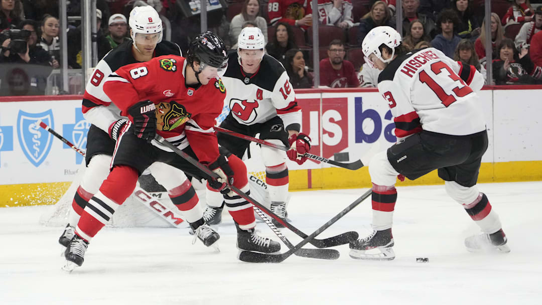 Mar 26, 2025; Chicago, Illinois, USA; Chicago Blackhawks center Ryan Donato (8) and New Jersey Devils center Nico Hischier (13) go for the puck during the first period at United Center. Mandatory Credit: David Banks-Imagn Images