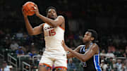 Feb 25, 2025; Coral Gables, Florida, USA;  Miami (Fl) Hurricanes forward Kiree Huie (15) grabs a rebound as Duke Blue Devils center Patrick Ngongba II (21) defends during the second half at Watsco Center. Mandatory Credit: Jim Rassol-Imagn Images